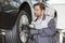 Male mechanic repairing car\'s wheel in workshop