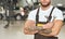 Male mechanic standing with folded arms and keeping wrench