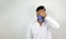 A male medical professional in white coat and mask in white background. stressed out doctor hiding identity. concept