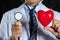 Male medicine doctor wearing hold in hands red toy heart