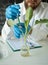 Male microbiologist looking at a healthy green plant in a sample flask. Medical scientist working in a food science lab