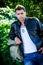 Male Model leaning on a stone wall.