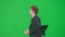 Male model in suit isolated on chroma key green screen background. Positive young businessman in blue suit running fast.