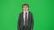 Male model in suit isolated on chroma key green screen background. Positive young businessman in blue suit walking.