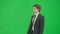 Male model in suit isolated on chroma key green screen background. Positive young businessman in blue suit walking.