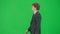 Male model in suit isolated on chroma key green screen background. Positive young businessman in blue suit walking.