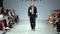 Male model walks on the catwalk during a fashion show. Slow motion.