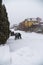 A male motorcyclist in a special outfit pushes his motorcycle on a snowy slippery road. Winter fun, stupid idea