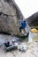 Male mountain climber climbing a highball boulder in a base camp in the Andes in Peru