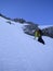 Male mountain climber heading up a steep snow gully and couloir early in the morning on his way to a high alpine peak in Switzerla