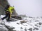 Male mountain climber heading up a steep snow and rock slope in bad weather in the high alps of Switzerland