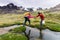 Male mountain climber helps partner cross a river in the Andes of Peru