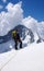 Male mountain climber looks towards the summit and his goal while standing o n a high alpine glacier