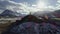 Male mountain climber raising hands with icepick on top of snowy peak. hiker at the top of a rock with his hands raised