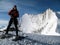 Male mountain climber smiling and laughing on the summit of a high alpine peak with a great backdrop of fantastic mountains