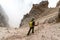 Male mountain climber on a steep scree and rock descent in the Dolomites of Italy in Alta Badia