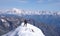 Male mountain climber on the summit of Gran Paradiso with a great view of Mont Blanc behind him