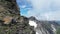 Male mountaineer (man) climbing rocks towards mountain panorama in Texel group, South Tyrol, Italy