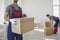 Male movers team carry boxes at relocation