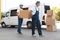 Male movers unloading boxes from van