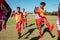 Male multiracial athletes stretching legs while exercising on playground against clear sky in summer