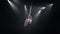 Male muscular circus artist on aerial straps doing strong tricks in the air on black background