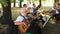 Male musicians play guitar and drums in orchestra performing open air