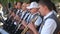 Male musicians play wind instruments in orchestra performing open air