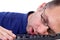 Male nerdy geek fall asleep on keyboard