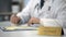 Male neurologist in uniform typing on laptop in clinic, keeping medical records