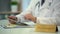 Male neurosurgeon viewing MRI test results on tablet in clinic, typing reports