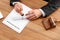 Male notary sealing document at wooden table