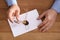 Male notary sealing document at wooden table