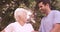 Male nurse assisting a senior woman to walk in the backyard