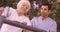 Male nurse assisting a senior woman to walk in the backyard