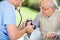 Male Nurse Checking Blood Pressure Of Senior Man