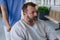 Male nurse pushing a patient in a wheelchair along a hospital corridor. Overweight patient feeling anxious and has