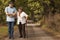 Male nurse supporting happy woman with walking stick in the forest