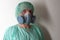 Male nurse, with twin filter half face respirator mask , cap, gown,  with  personal protective equipment to protect against the