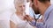 Male nurse using stethoscope on senior woman