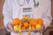 Male nutritionist holding fresh fruits, calculator while standing