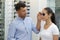 male optician fitting sunglasses on female customer