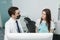 Male orthodontist with female patient looking on a screen during a medical consultation at the dental office