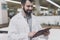 A male orthopedic pose against the background of a large store of beds. He holds tablet in his hands and looks at him.