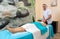 Male osteopath therapist massages neck of patient, after injury.