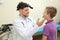 Male otolaryngologist examining little child