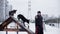 Male owner playing with funny dog on training ground in winter day. Cheerful man training two playful dogs on winter