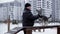 Male owner training dog on playground at winter city. Fluffy dog giving paw to owner while winter walk on training