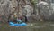 Male paddler is paddling inflatable packraft upstream of a mountain river