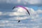 Male paragliding against a cloudy blue sky